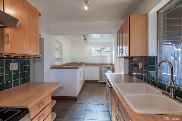 kitchen featuring sink, light tile patterned floors, tasteful backsplash, and radiator