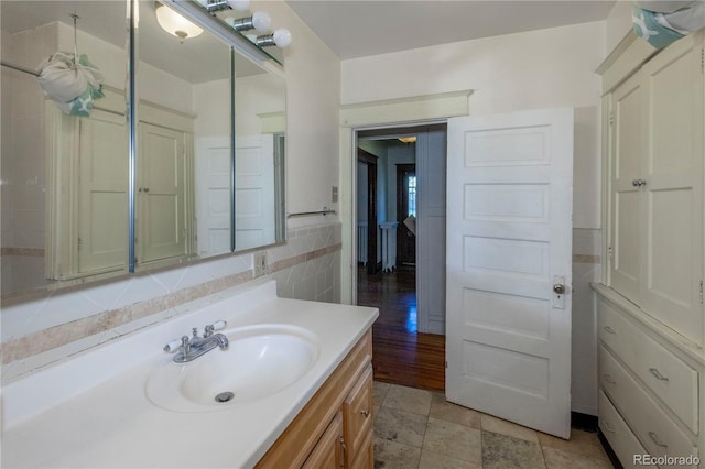 bathroom featuring vanity and tile walls