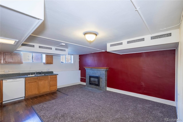 kitchen with a brick fireplace, dark hardwood / wood-style floors, dishwasher, and sink