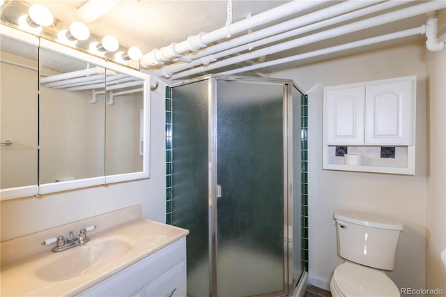 bathroom with toilet, a shower with door, and vanity