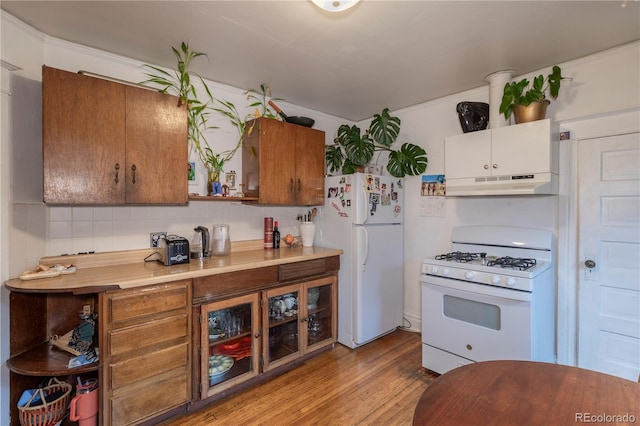 kitchen featuring white appliances, backsplash, and light hardwood / wood-style flooring