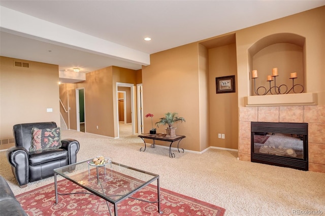 carpeted living room with a tiled fireplace