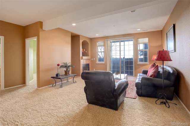 carpeted living room with a tiled fireplace