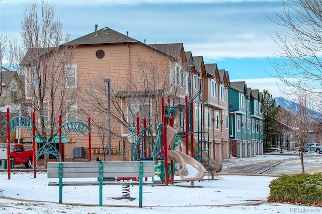 snow covered playground featuring a mountain view