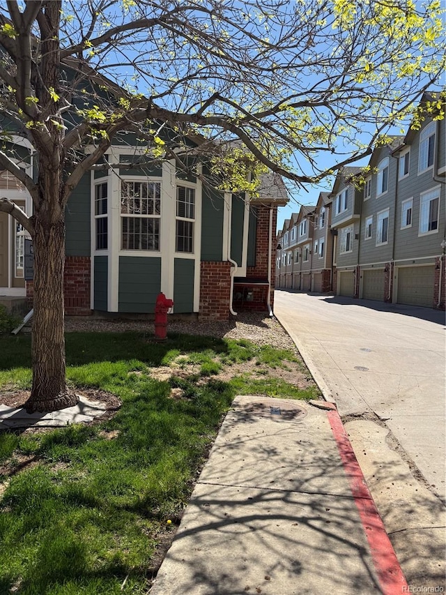 view of property exterior with brick siding and a residential view