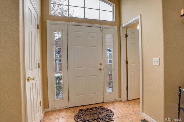 foyer featuring light tile patterned floors and baseboards