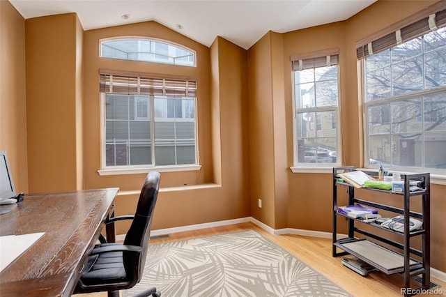 office space with wood finished floors, healthy amount of natural light, vaulted ceiling, and baseboards