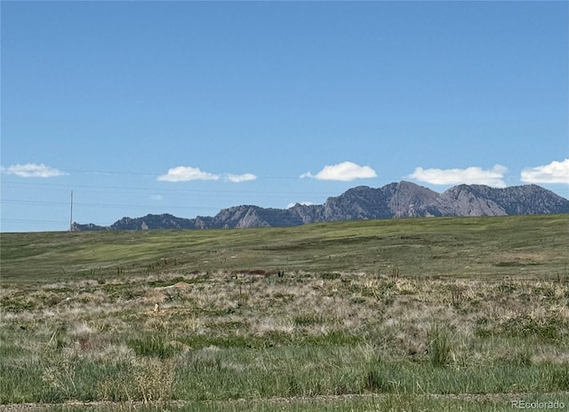 view of mountain backdrop with rural landscape