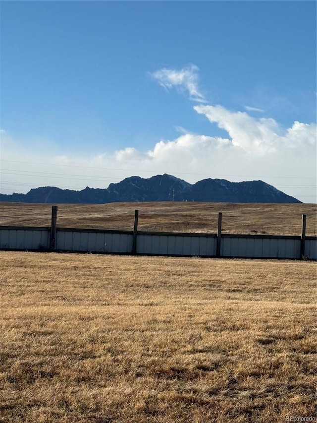 view of yard with a rural view, a mountain view, and fence