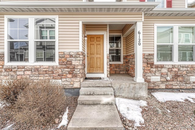 doorway to property featuring stone siding