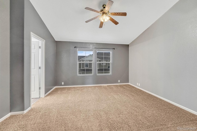 carpeted empty room featuring baseboards, a ceiling fan, and lofted ceiling