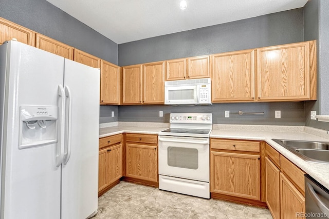 kitchen with white appliances, light countertops, and a sink