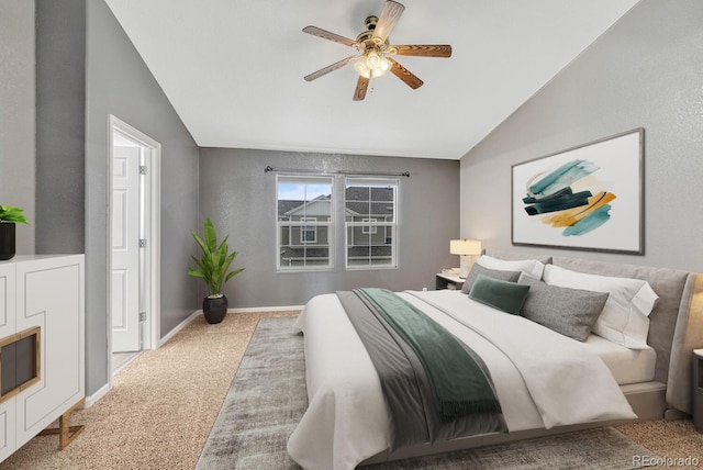 carpeted bedroom with lofted ceiling, connected bathroom, baseboards, and ceiling fan