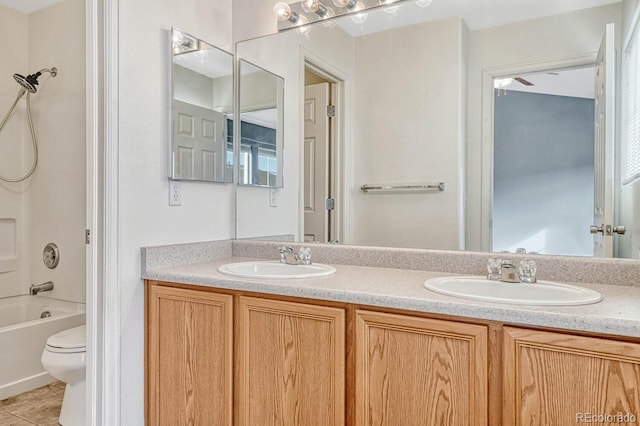 bathroom featuring double vanity, toilet, shower / tub combination, and a sink