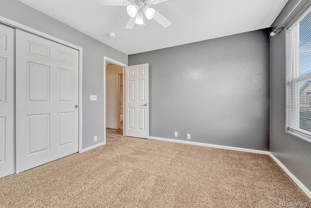 unfurnished bedroom with carpet flooring, a ceiling fan, and baseboards