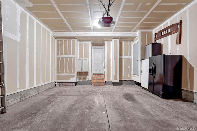 garage featuring fridge with ice dispenser, a garage door opener, and black refrigerator with ice dispenser