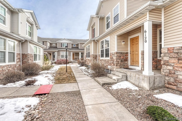 entrance to property with stone siding and a residential view