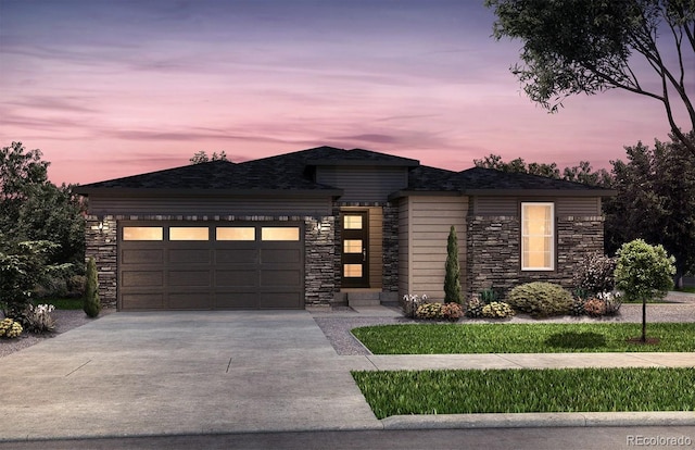 4125 N Duquesne Ct, Aurora, CO 80019 - view of front of house with stone siding, a garage, and concrete driveway