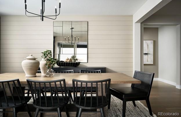 4125 N Duquesne Ct, Aurora, CO 80019 - dining room featuring a chandelier, wooden walls, and wood finished floors