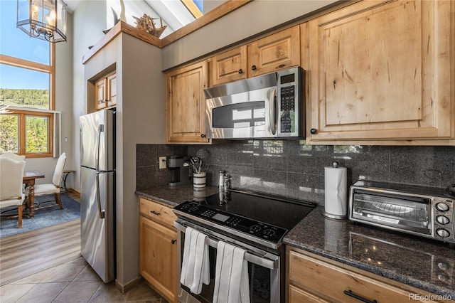 22300 US Highway 6 Unit 1746, Dillon, CO 80435 - kitchen with stainless steel appliances, tasteful backsplash, dark stone countertops, light tile patterned floors, and hanging light fixtures