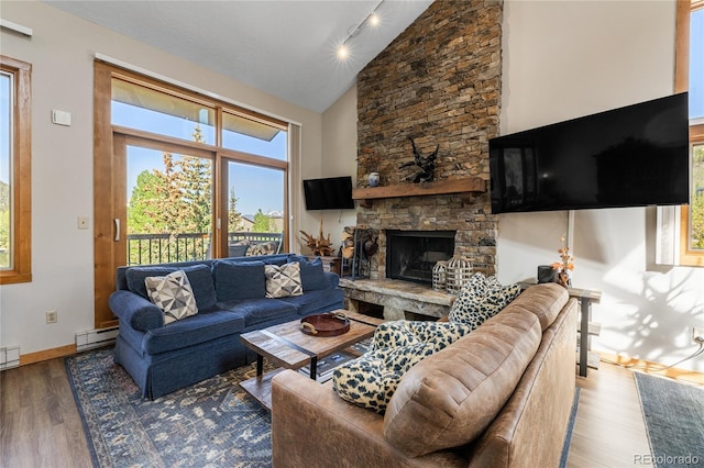 22300 US Highway 6 Unit 1746, Dillon, CO 80435 - living area featuring a baseboard heating unit, wood finished floors, rail lighting, a stone fireplace, and high vaulted ceiling