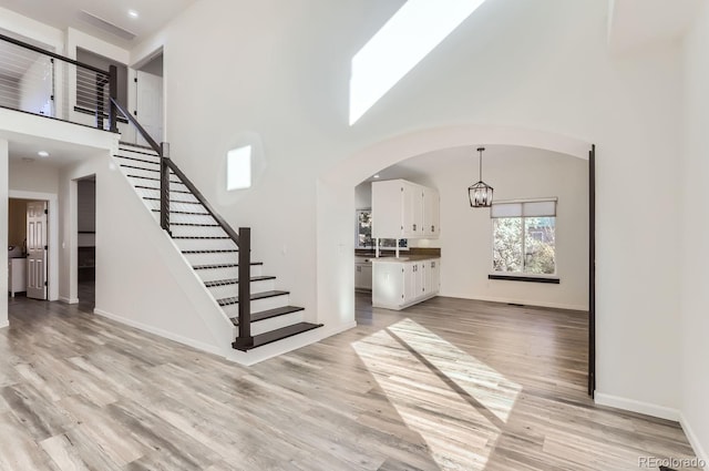 foyer featuring a high ceiling, a chandelier, and light hardwood / wood-style flooring