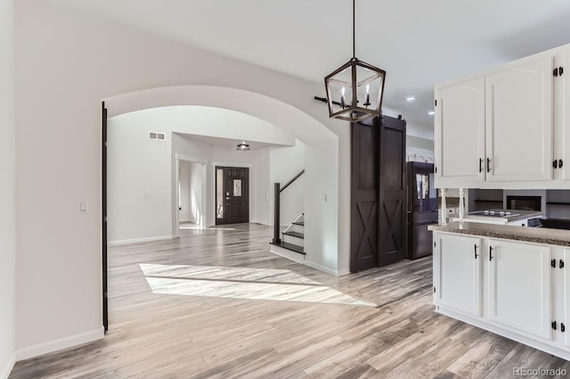 kitchen featuring light hardwood / wood-style flooring, pendant lighting, and white cabinets