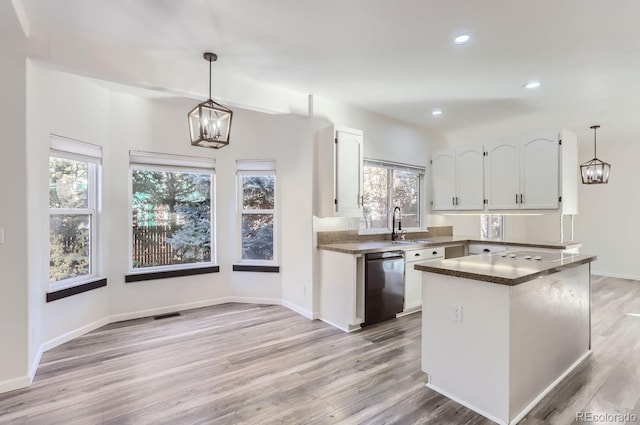 kitchen with hanging light fixtures, white cabinetry, light wood-type flooring, and black dishwasher