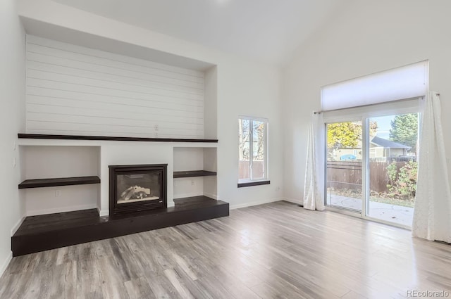 unfurnished living room featuring lofted ceiling and wood-type flooring