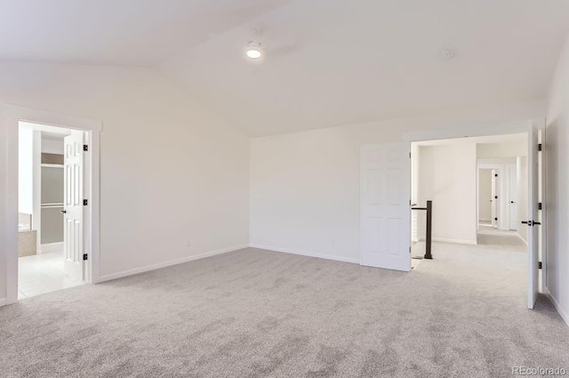 carpeted spare room featuring vaulted ceiling