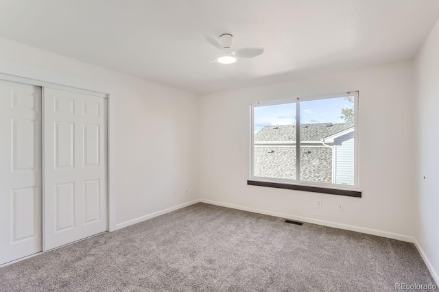 unfurnished bedroom with carpet flooring, ceiling fan, and a closet