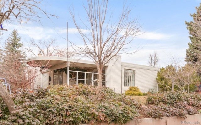 view of property exterior with a sunroom