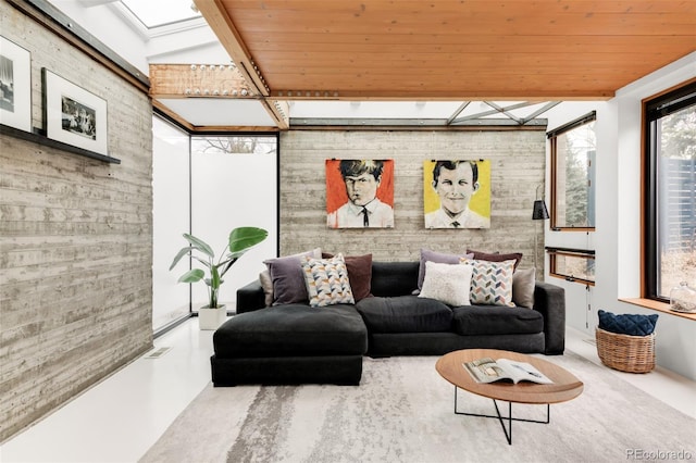 living room with visible vents, brick wall, wood ceiling, concrete flooring, and a skylight