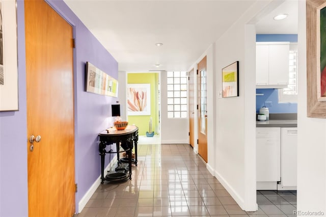 hallway featuring light tile patterned floors and baseboards