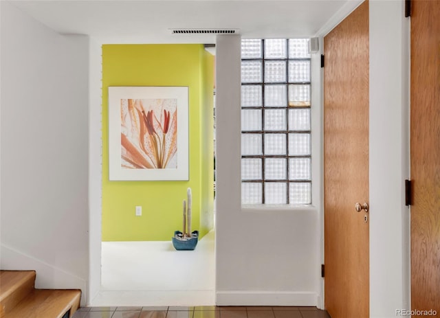 interior space featuring stairway, baseboards, and visible vents