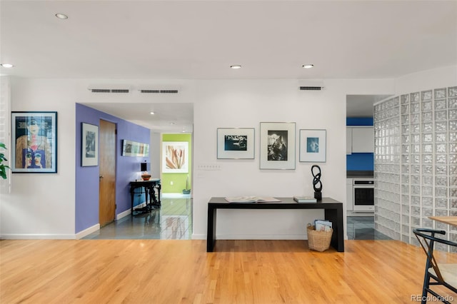 interior space with recessed lighting, wood finished floors, visible vents, and baseboards