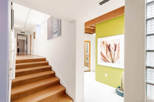 stairs featuring visible vents and rail lighting