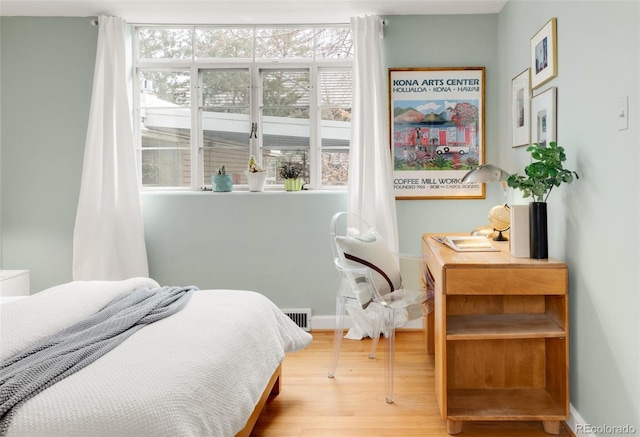 bedroom with visible vents, baseboards, and wood finished floors