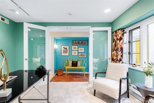 living area featuring visible vents, baseboards, carpet flooring, rail lighting, and tile patterned floors