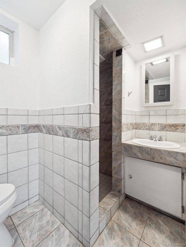 3050 S Delaware St, Englewood, CO 80110 - full bath featuring tile walls, vanity, and a tile shower