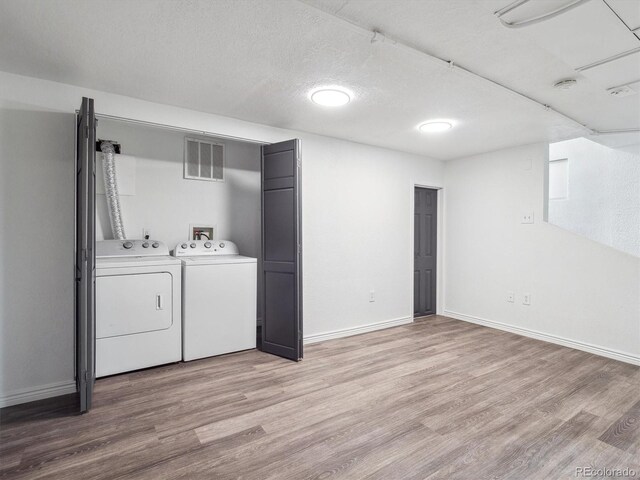 3050 S Delaware St, Englewood, CO 80110 - laundry area featuring washer and clothes dryer, light wood-style flooring, and a textured ceiling