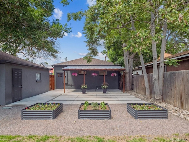 3050 S Delaware St, Englewood, CO 80110 - back of property with a vegetable garden and a patio
