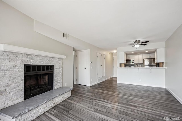 4273 S Salida Way Unit 1, Aurora, CO 80013 - unfurnished living room featuring dark wood-type flooring, a ceiling fan, baseboards, a fireplace, and recessed lighting