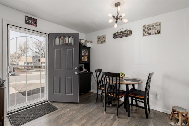 dining area featuring a notable chandelier, baseboards, and wood finished floors