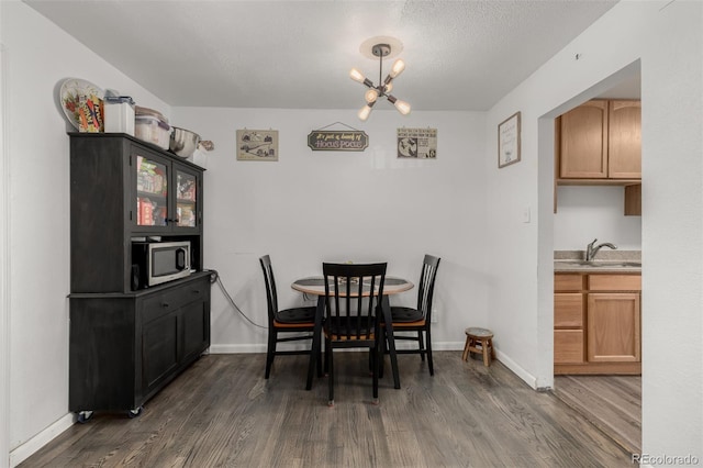 dining room featuring an inviting chandelier, baseboards, dark wood-style flooring, and a textured ceiling