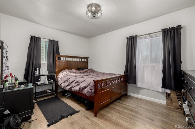 bedroom featuring baseboards and light wood-style flooring