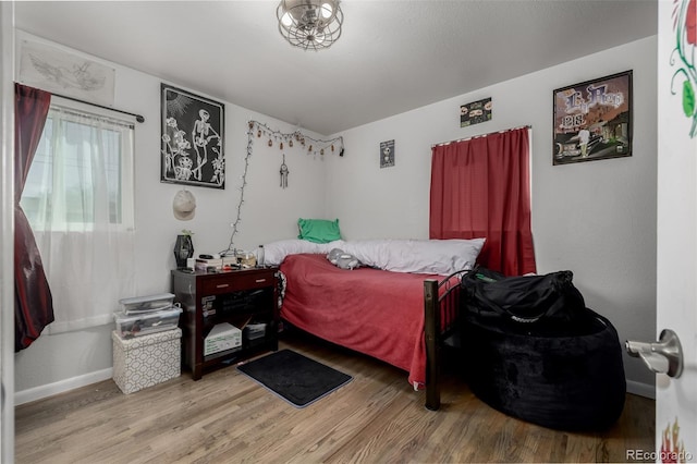 bedroom featuring wood finished floors and baseboards