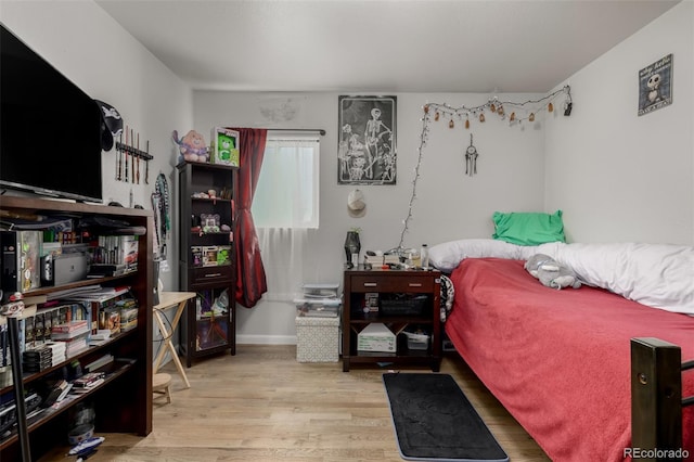 bedroom with baseboards and wood finished floors