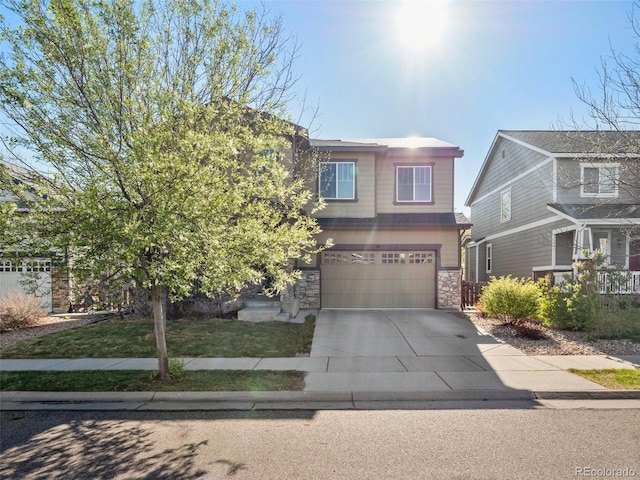 41 Garner Ln, Erie, CO 80516 - view of front facade featuring an attached garage, stone siding, and concrete driveway