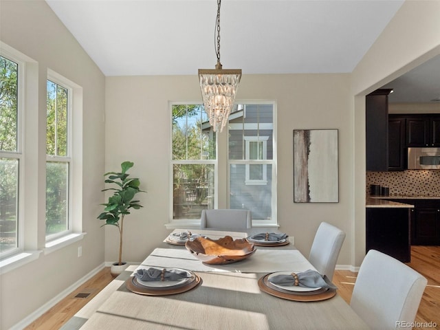 41 Garner Ln, Erie, CO 80516 - dining room featuring a chandelier, light wood-type flooring, baseboards, and lofted ceiling